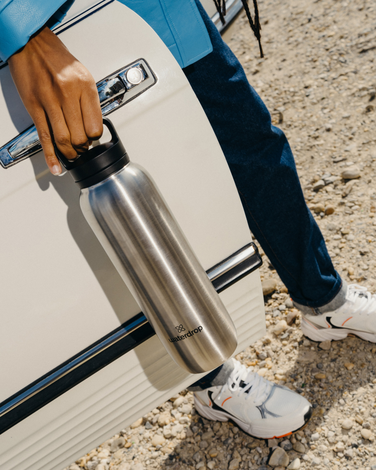 Person holding All-Purpose Thermo · Spout Lid, a double-walled stainless steel bottle designed to keep drinks cold for up to 24 hours.