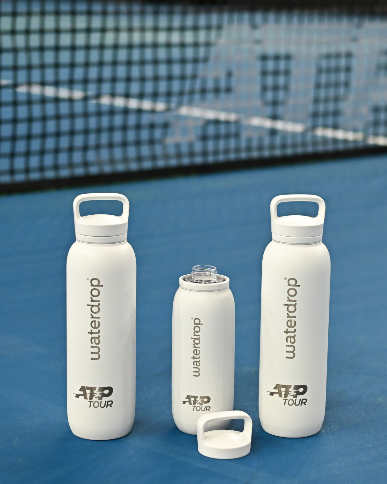 Official ATP Tour waterdrop all-purpose Thermo with Spout Lid bottles on a tennis court, designed for ATP Tour 2024, featuring stainless steel insulation and ice cube-friendly spout lids.