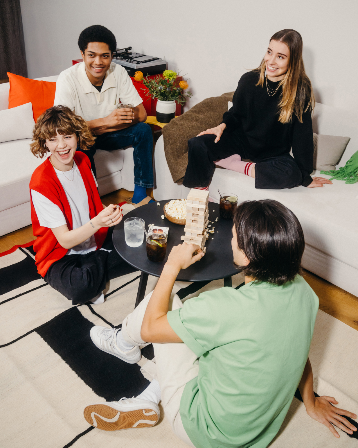 People sitting on the floor playing with blocks, enjoying a refreshing COLA drink in a glass with ice and lime.