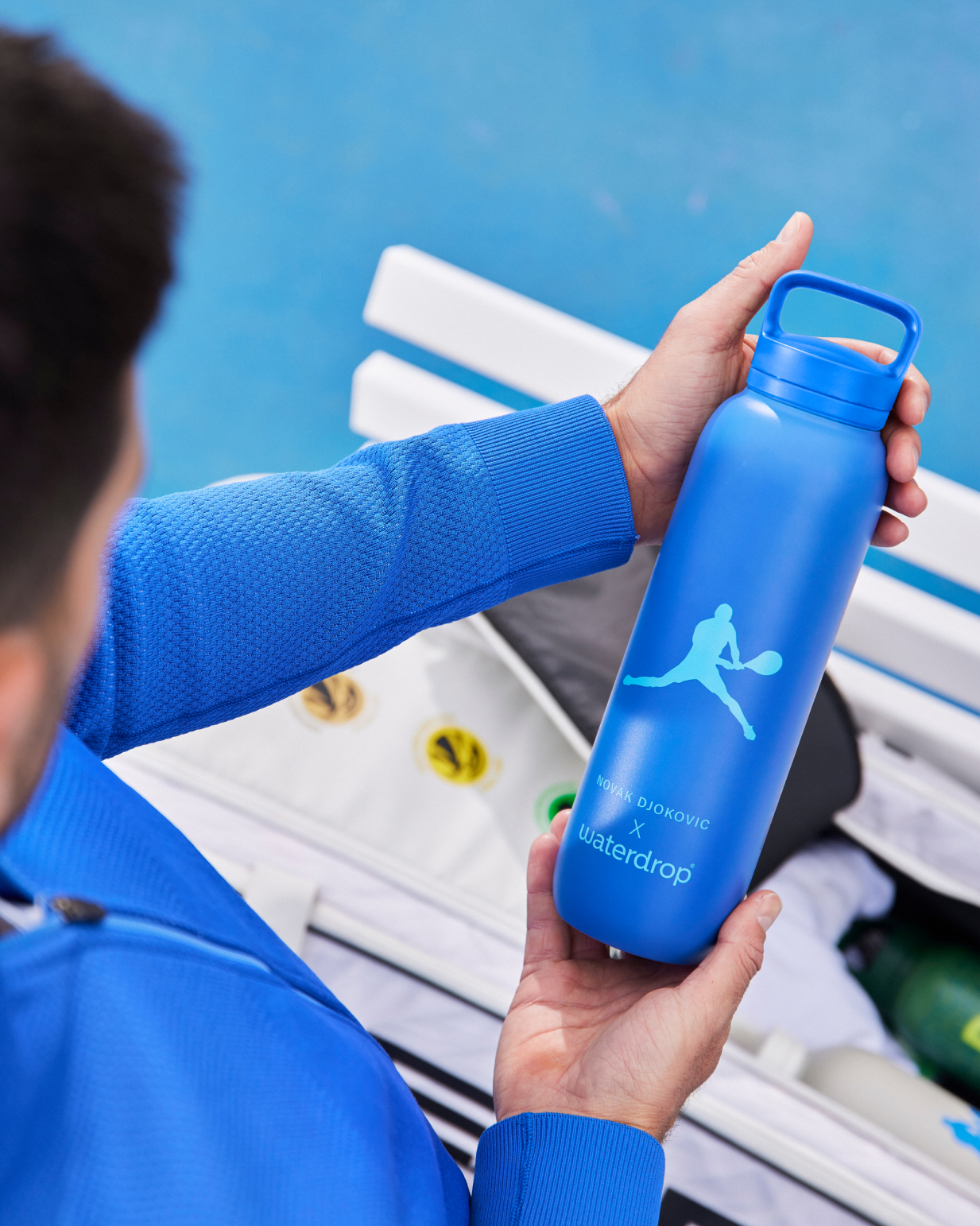 Novak holding the Djokovic Thermo Bottle, made for use with SILA electrolyte hydration cubes by waterdrop®.