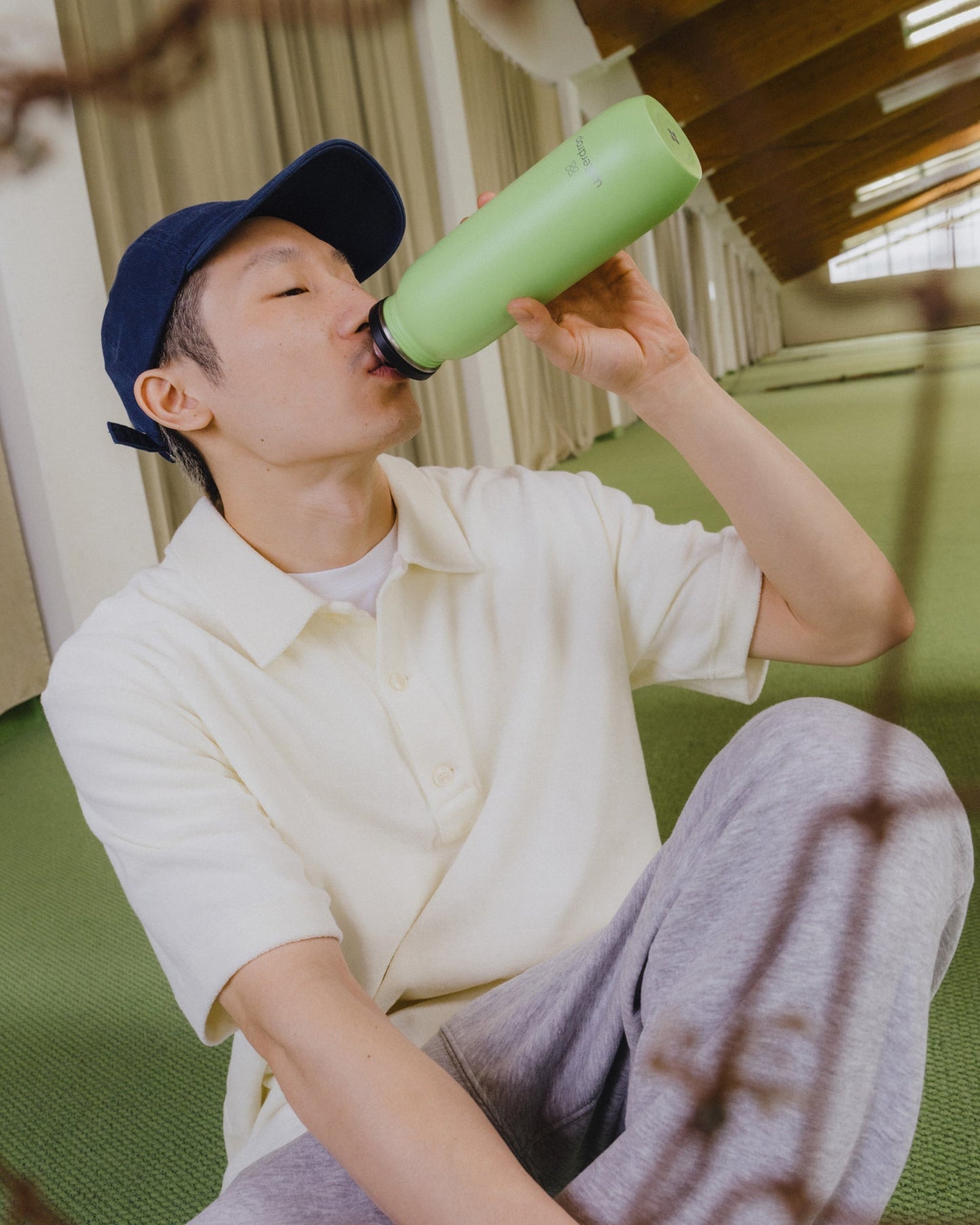 A man drinks from the All-Purpose Ultralight Bottle with Swing Lid, highlighting its practical and hygienic design.