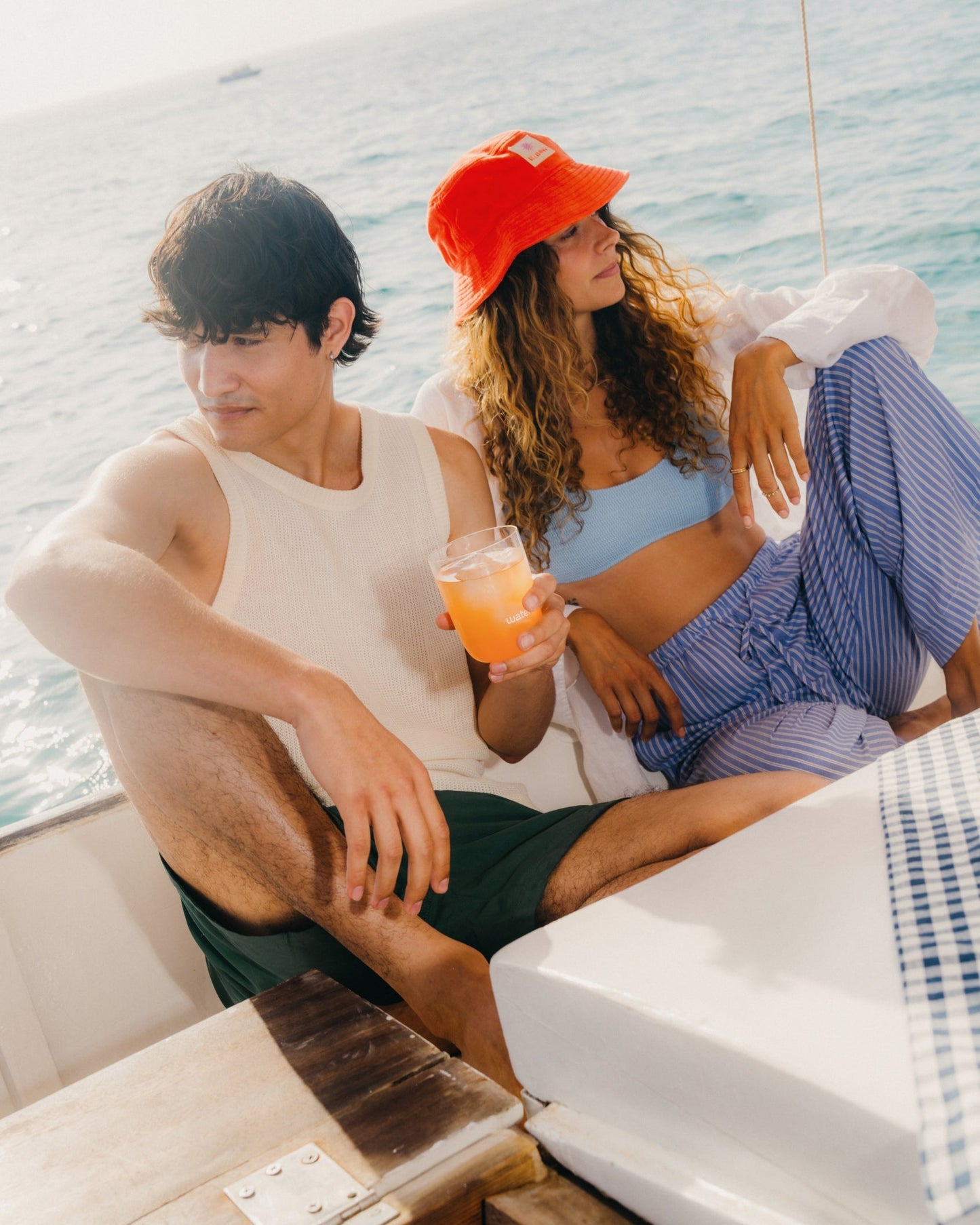 A man and woman sit on a boat, enjoying a glass of waterdrop® GRAPEFRUIT, capturing the essence of flavored hydration.