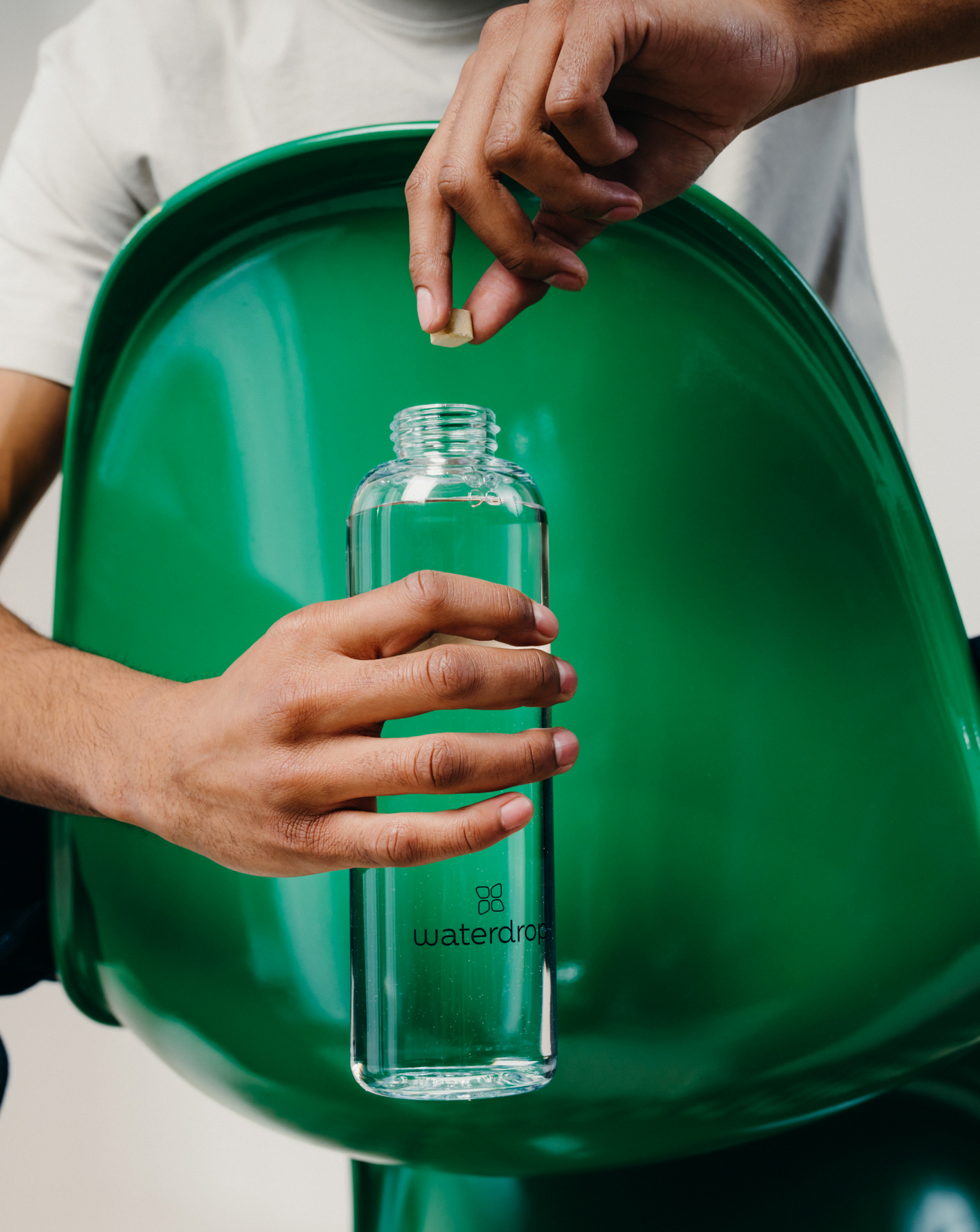 A person holding a Clear Glass Bottle, highlighting its minimalist design and transparency for monitoring daily hydration.