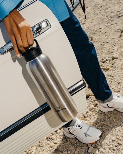 Person holding All-Purpose Thermo · Spout Lid, a double-walled stainless steel bottle designed to keep drinks cold for up to 24 hours.