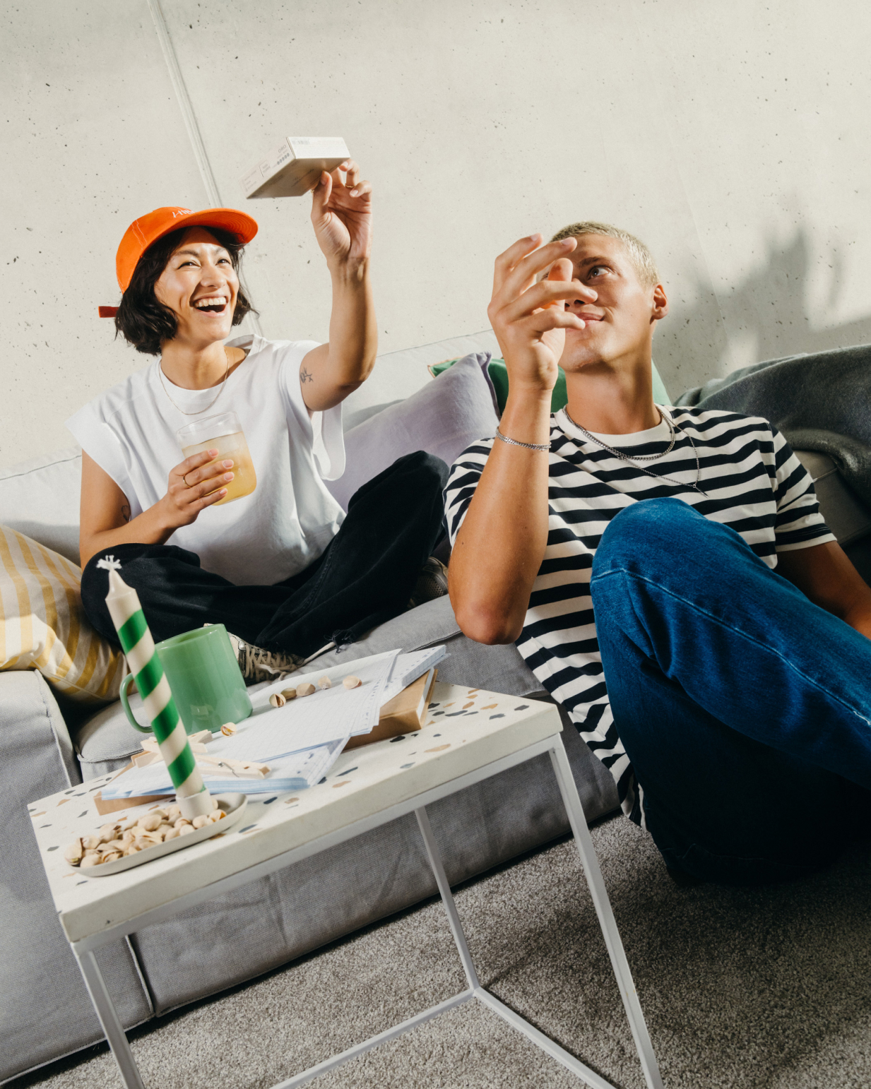 Twin Pack Microenergy: A man and woman enjoying Microenergy drinks on a couch, surrounded by papers and a green mug on the table.