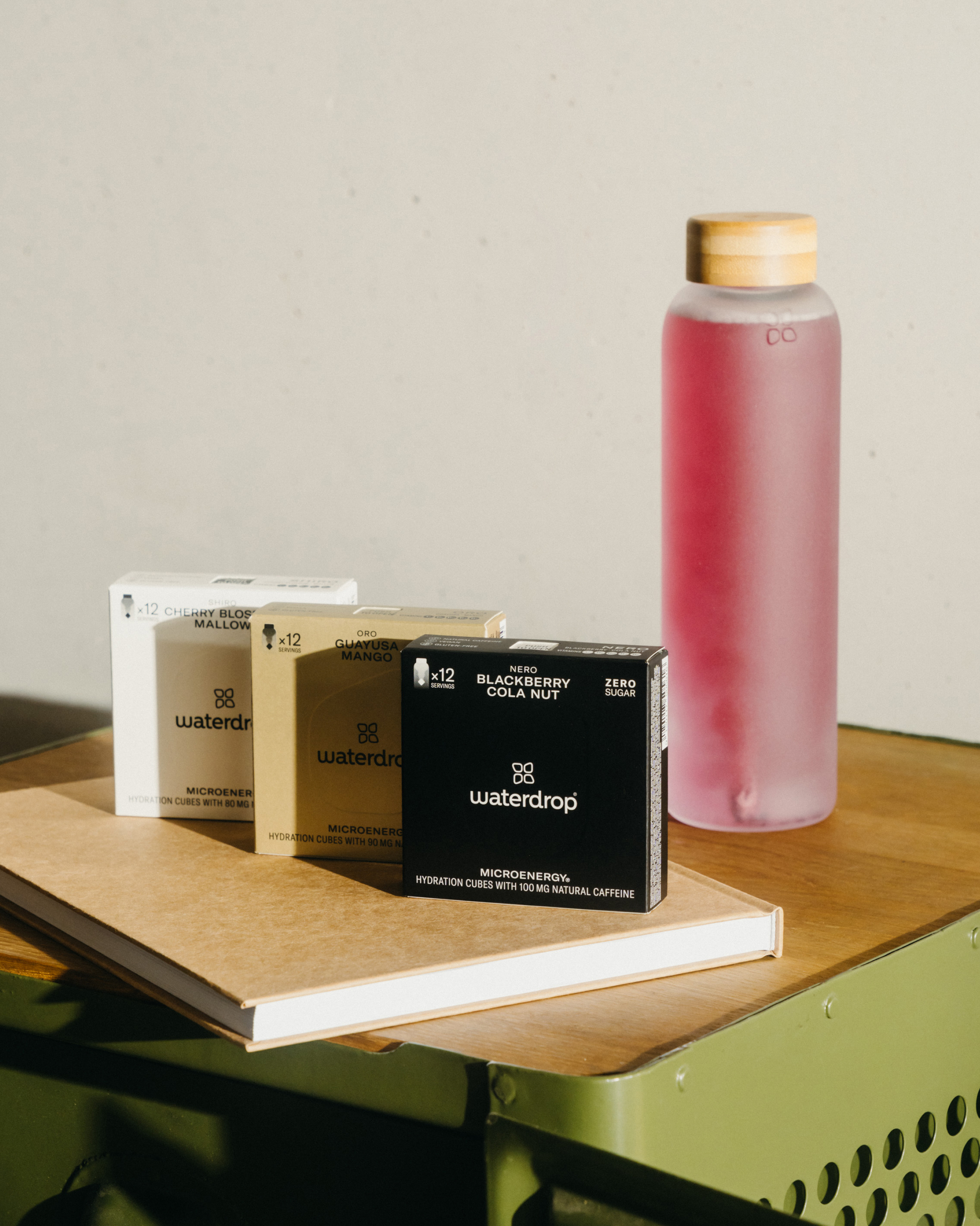 Twin Pack Microenergy bottles with natural caffeine and fruity flavors, displayed on a table alongside books and product boxes.