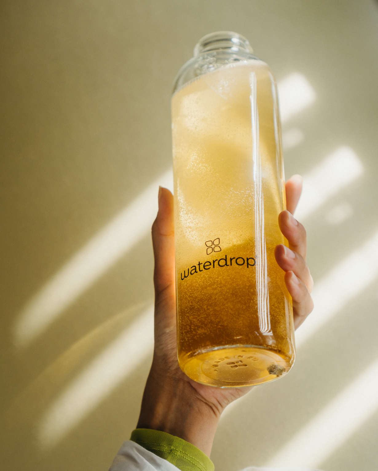Hand holding a bottle of Twin Pack Microenergy, featuring natural caffeine and fruity flavors, part of waterdrop®'s hydration solutions.