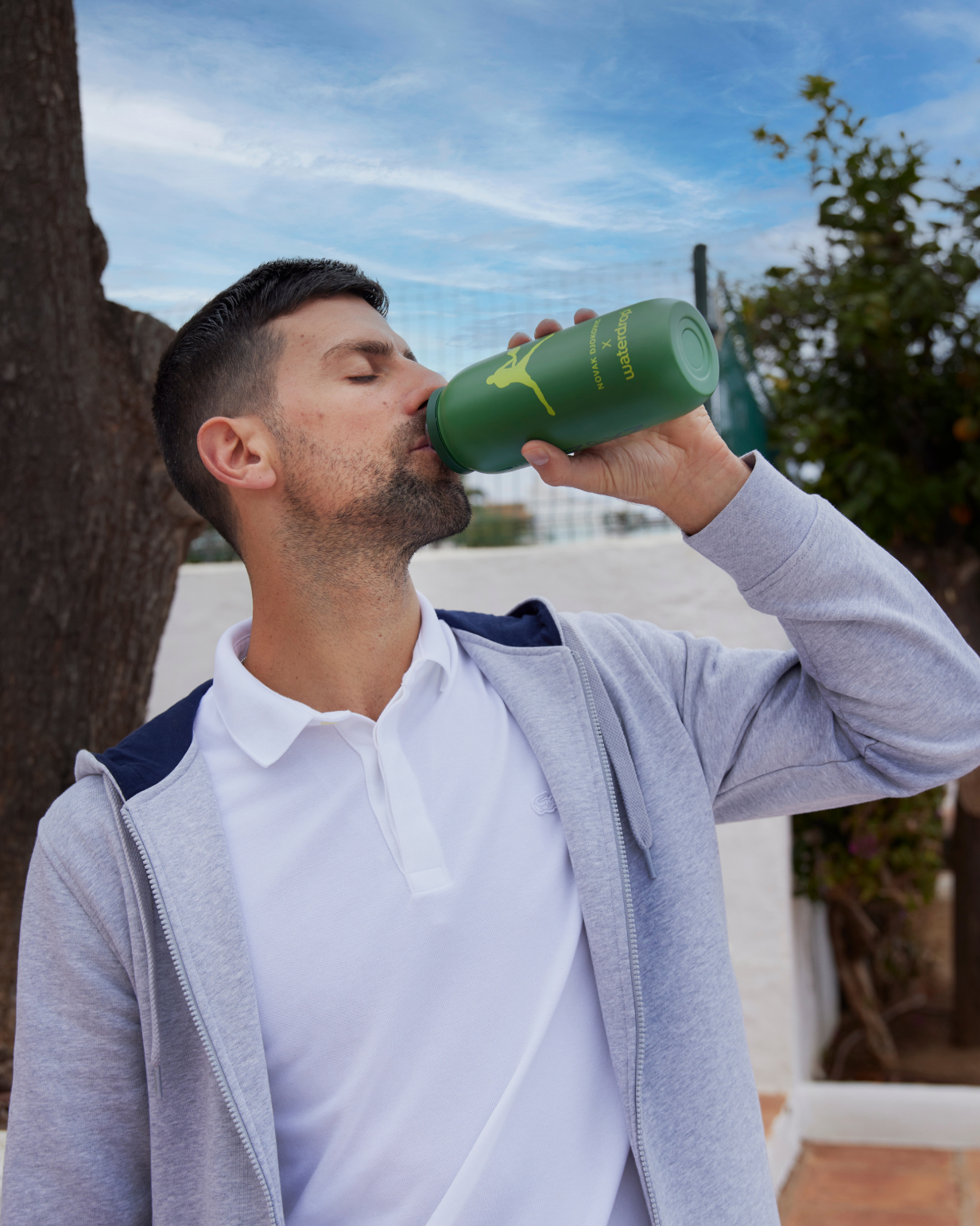 Man drinking from a green bottle, depicting the SILA Hydration Set with electrolyte cubes for enhanced hydration and recovery.