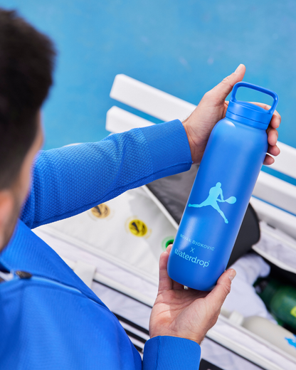 Novak holding the Djokovic Thermo Bottle, made for use with SILA electrolyte hydration cubes by waterdrop®.