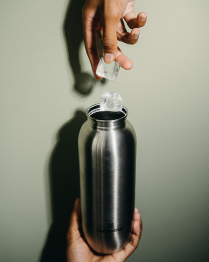 Person pouring ice into the All-Purpose Ultralight Bottle with Spout Lid, emphasizing its lightweight design and versatility for hydration on the go.