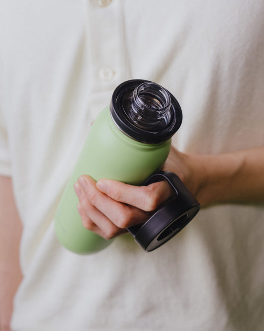 Person holding the All-Purpose Ultralight Bottle with Spout Lid, showcasing its lightweight design ideal for hiking and everyday use.