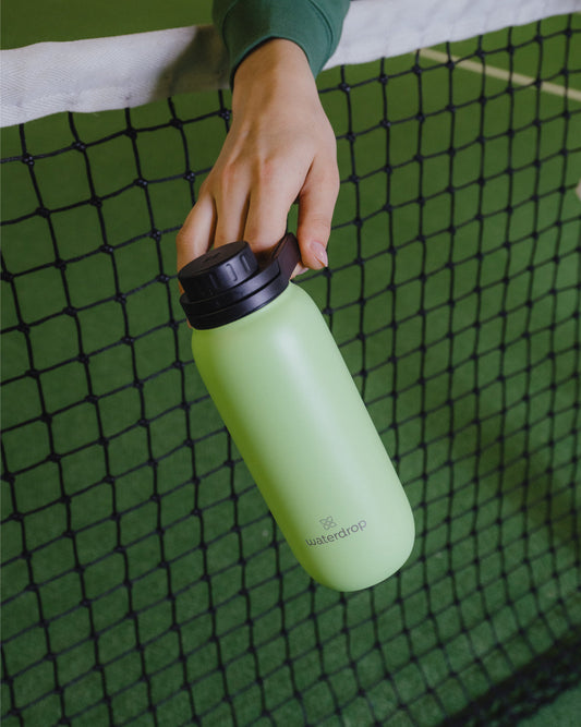 Hand holding All-Purpose Thermo bottle with Swing Lid, showcasing its vacuum-insulated design for long-lasting hydration.