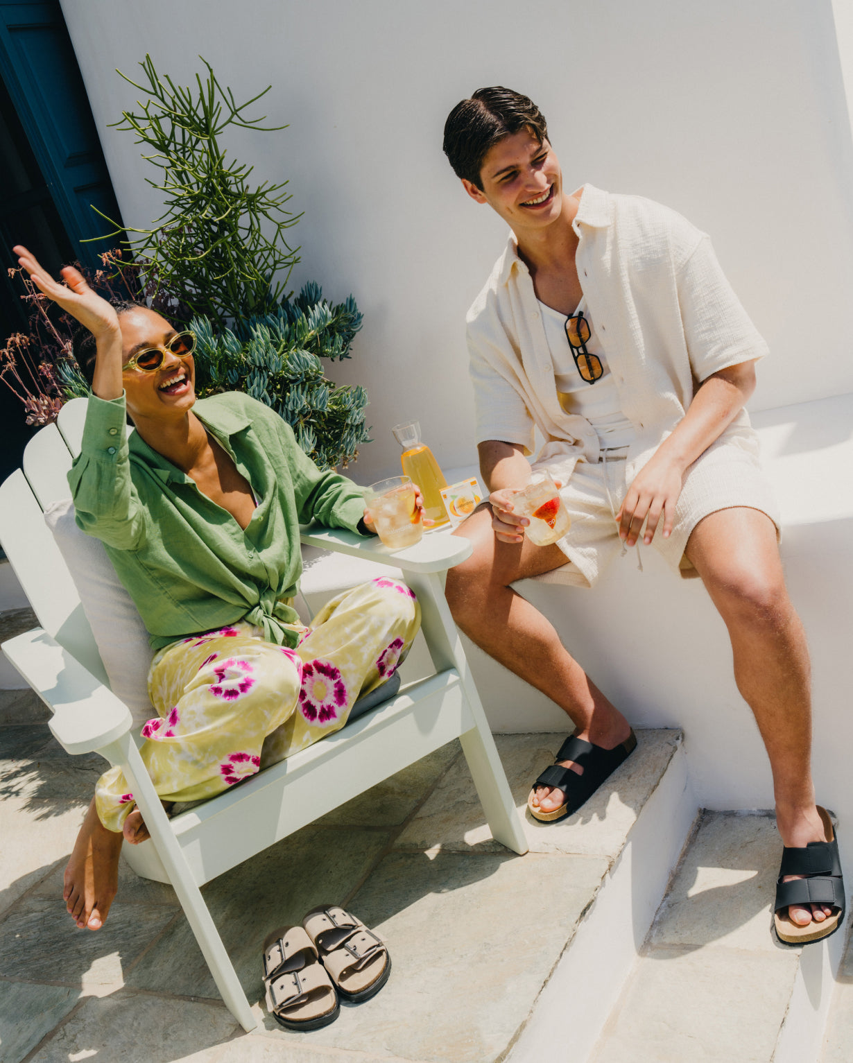 Man and woman enjoying drinks, highlighting ICE TEA Peach by waterdrop®, a no-sugar, peach-flavored black tea infusion transforming regular water into a refreshing beverage.
